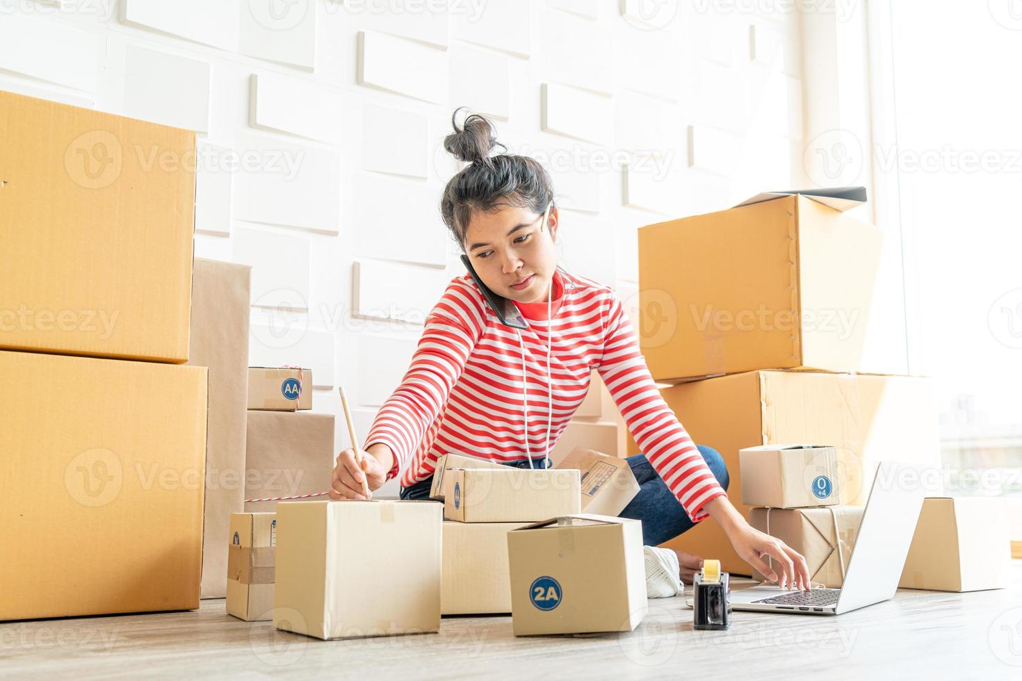 femme asiatique propriétaire d'entreprise travaillant à la maison avec une boîte d'emballage sur le lieu de travail - achat en ligne PME entrepreneur ou concept de travail indépendant photo