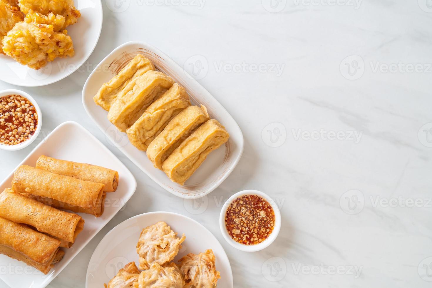 taro frit, maïs, tofu et rouleaux de printemps avec sauce - style végétalien et végétarien photo