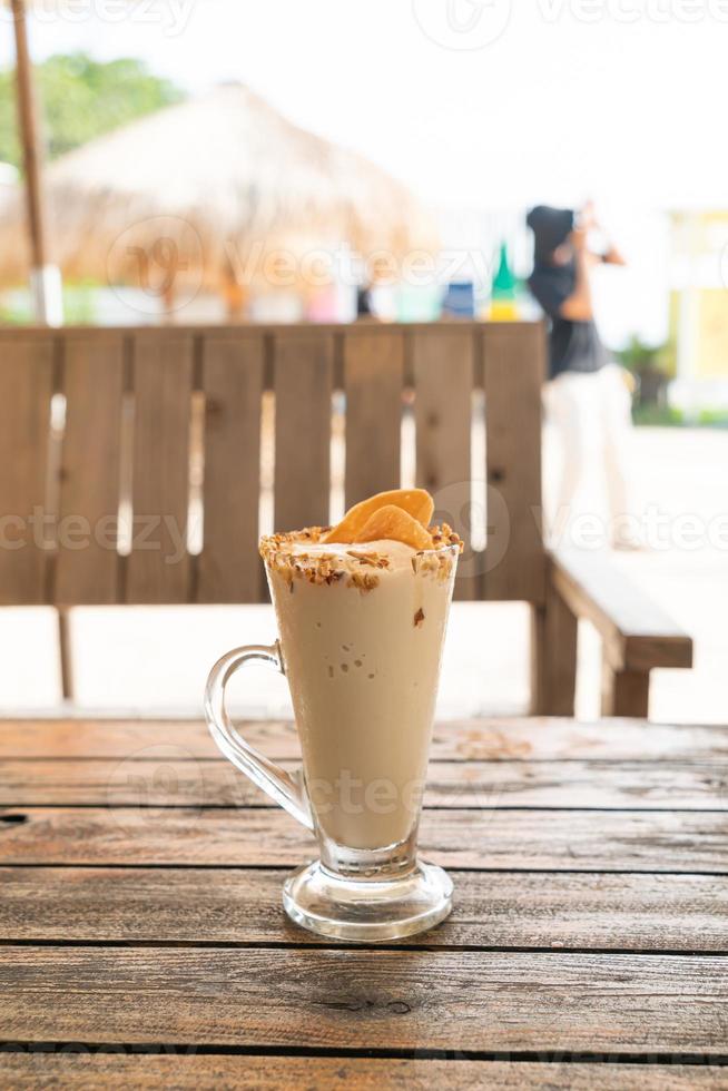 Verre de milkshake de smoothie de noix de café de caramel dans le café et le restaurant photo