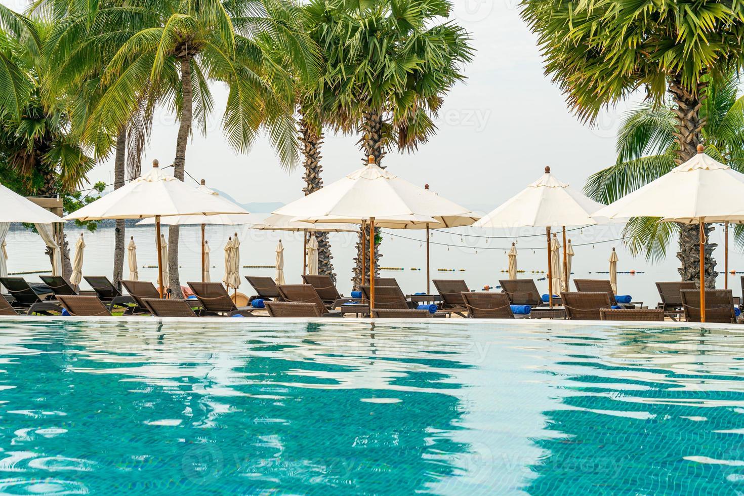 chaise de plage vide avec parasol autour de la piscine photo