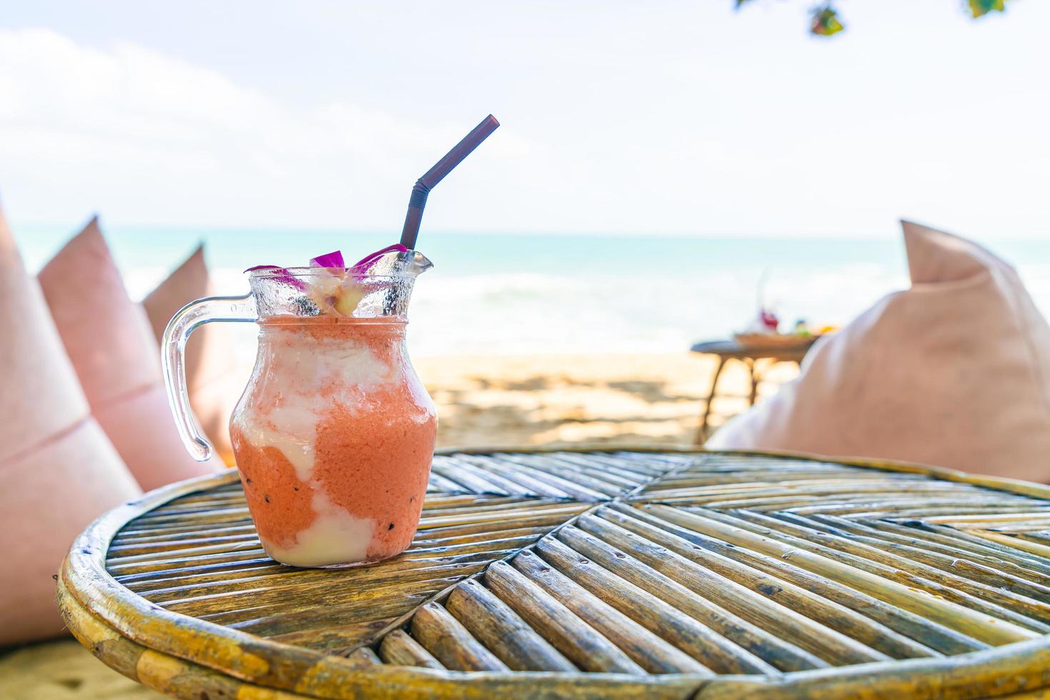 mangue, ananas, pastèque et pot de smoothies au yaourt ou au yaourt avec fond de plage de mer photo