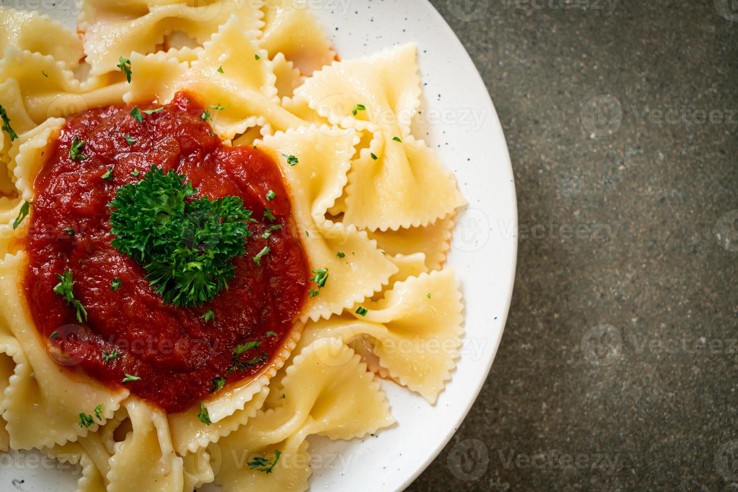 pâtes farfalle à la sauce tomate avec persil - style cuisine italienne photo