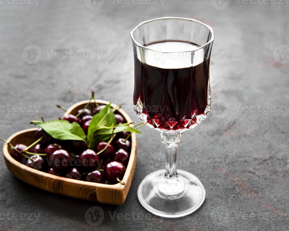 liqueur de cerise dans un verre et fruits frais photo