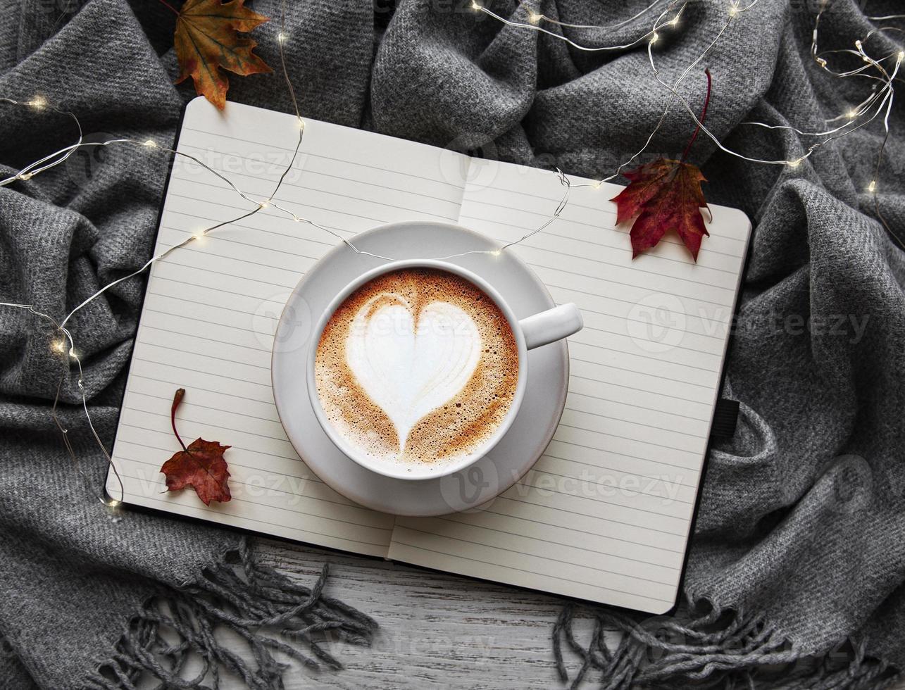 feuilles d'érable, cahier, tasse à café et écharpe. photo
