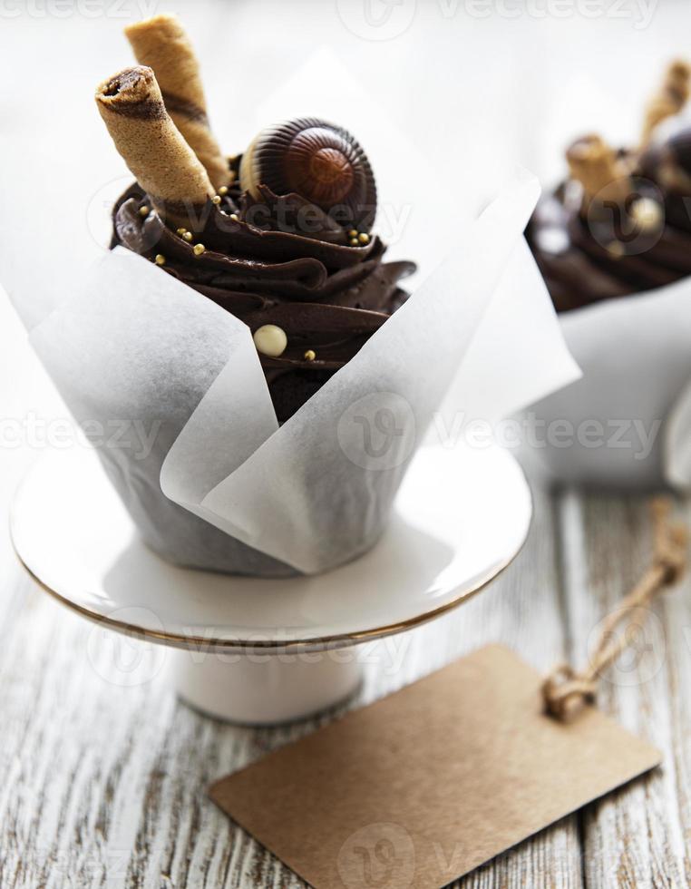 Petits gâteaux au chocolat sur fond de bois blanc photo