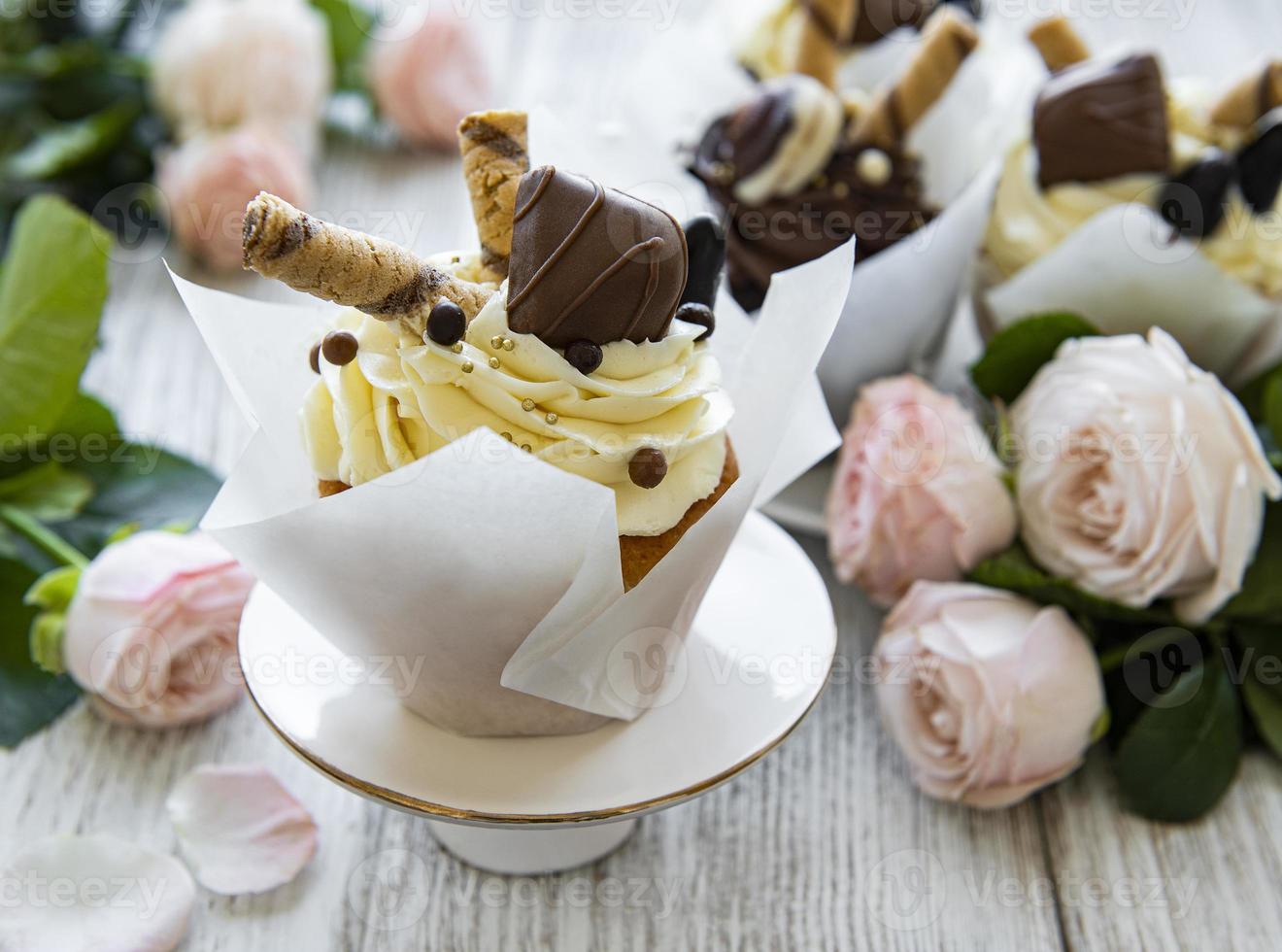 Petits gâteaux au chocolat sur fond de bois blanc photo