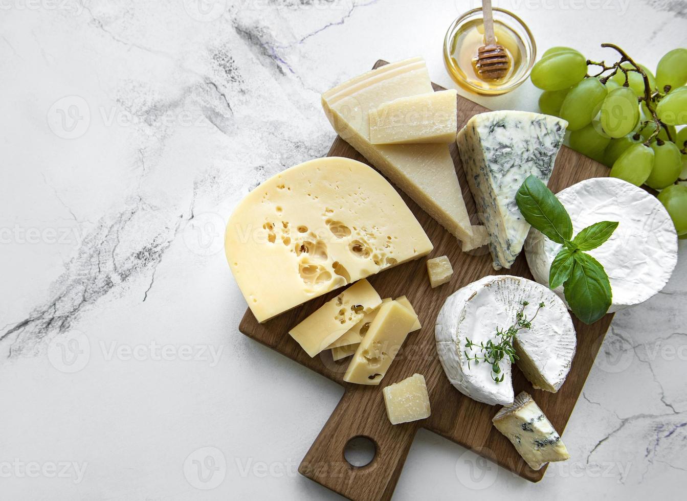 divers types de fromages, raisins et miel photo