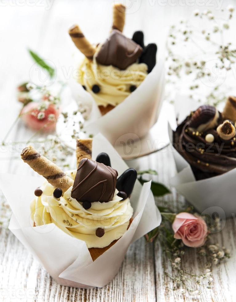 Petits gâteaux au chocolat sur fond de bois blanc photo