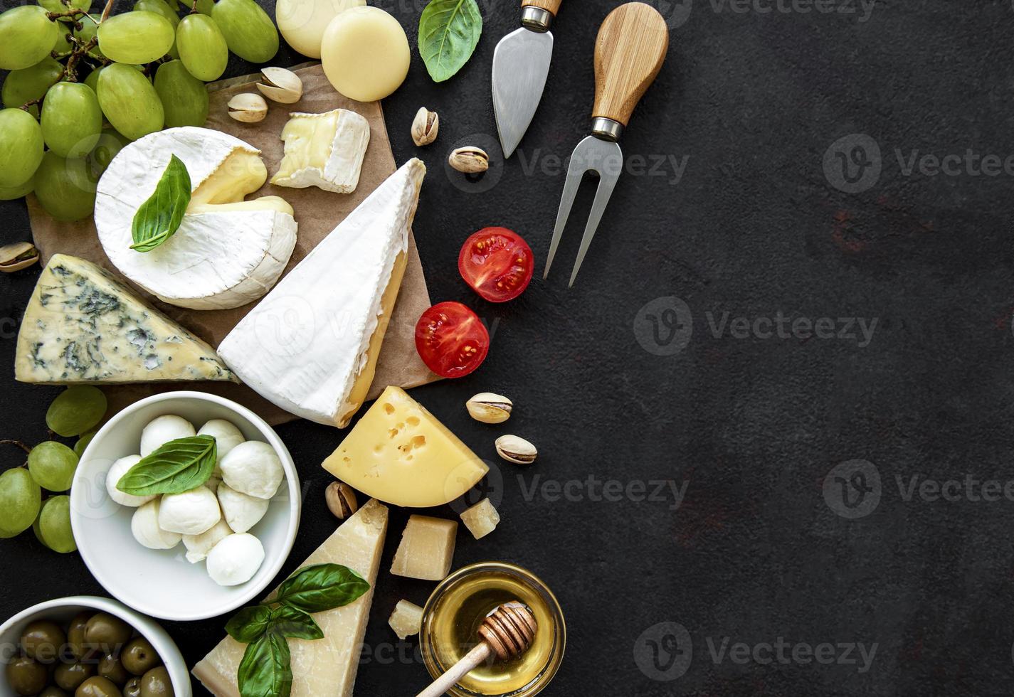 divers types de fromages, raisins, miel et collations photo