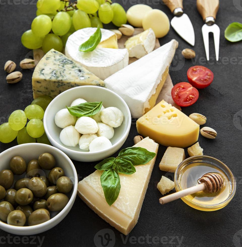 divers types de fromages, raisins, miel et collations photo