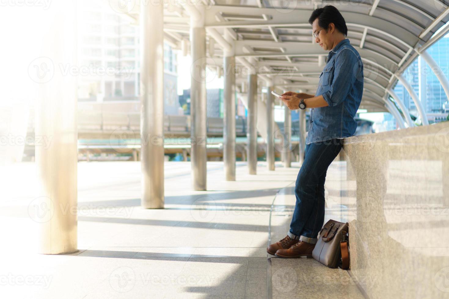 L'homme utilise une tablette dans la ville photo