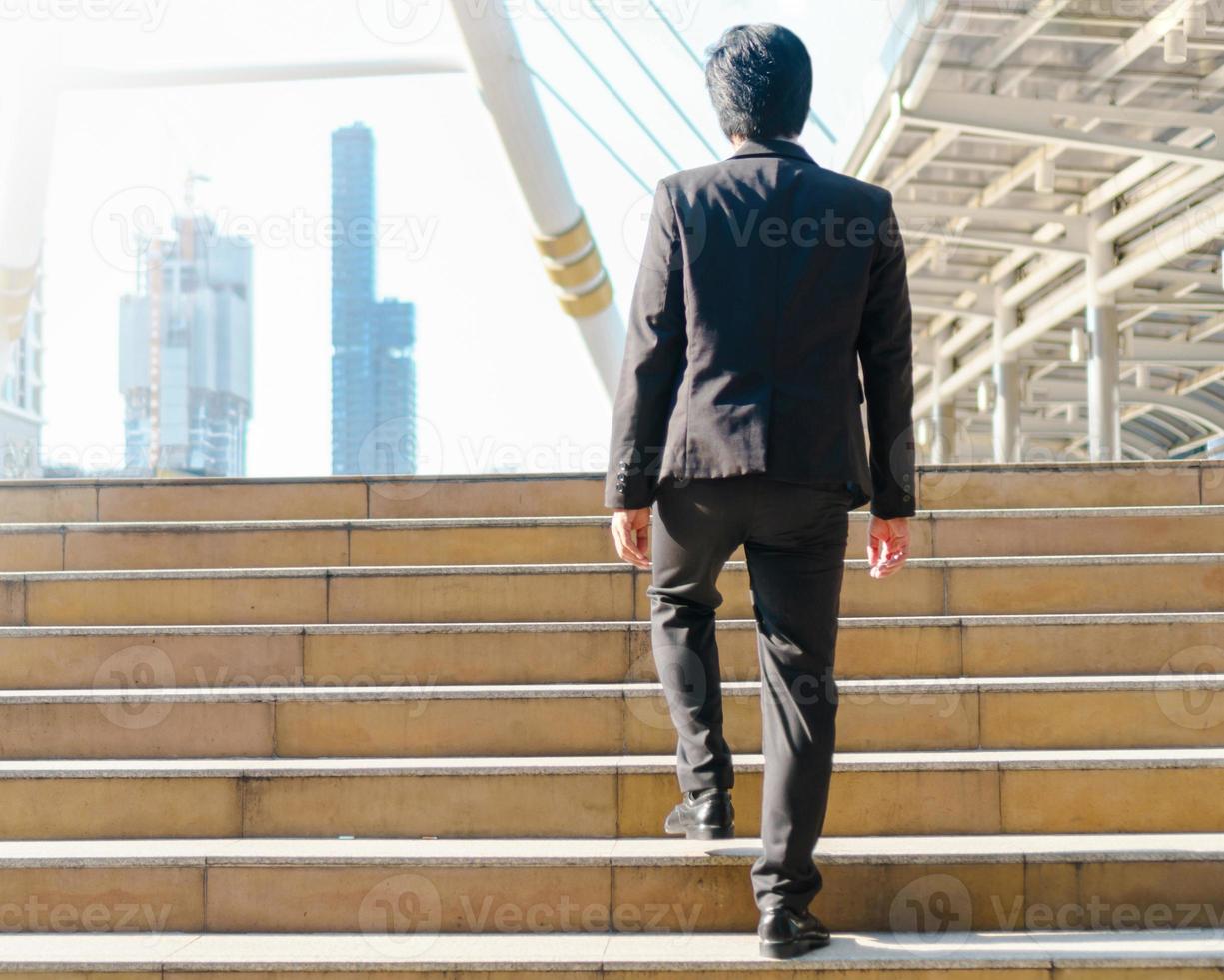 homme d'affaires marchant en plein air dans les pas de la rue dans la ville photo