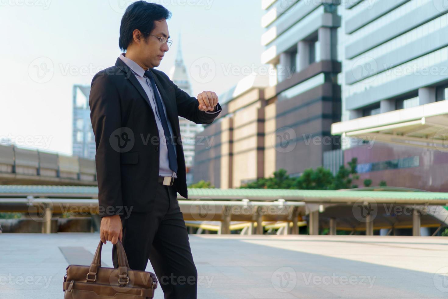 homme d'affaires marchant dans la ville et tenant une mallette photo