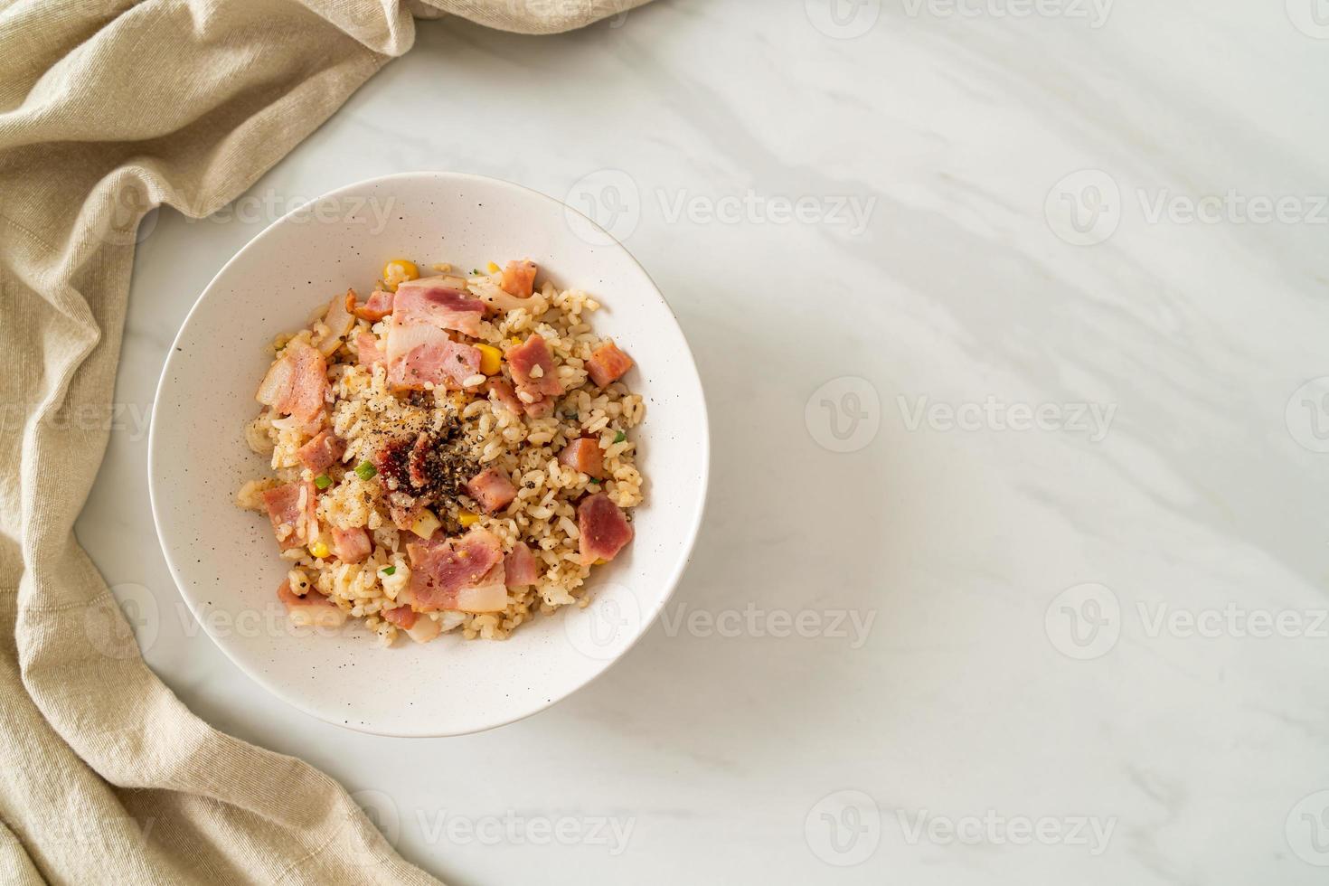 riz frit avec bacon, jambon et poivrons noirs sur plaque blanche photo