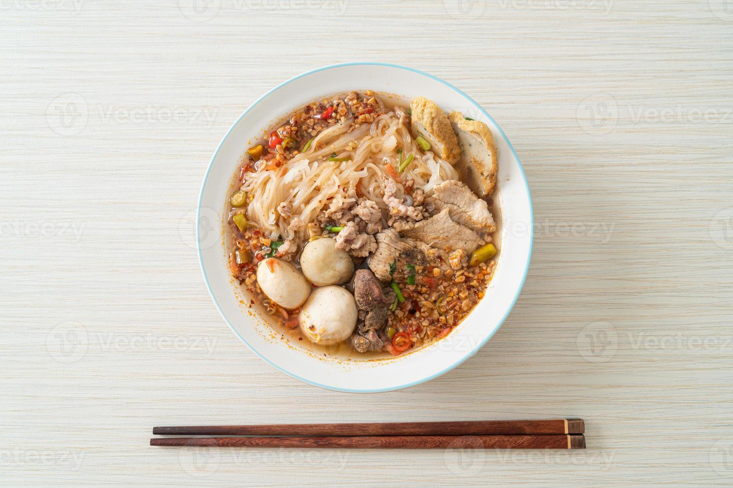 nouilles au porc et boulettes de viande dans une soupe épicée ou nouilles tom yum à l'asiatique photo