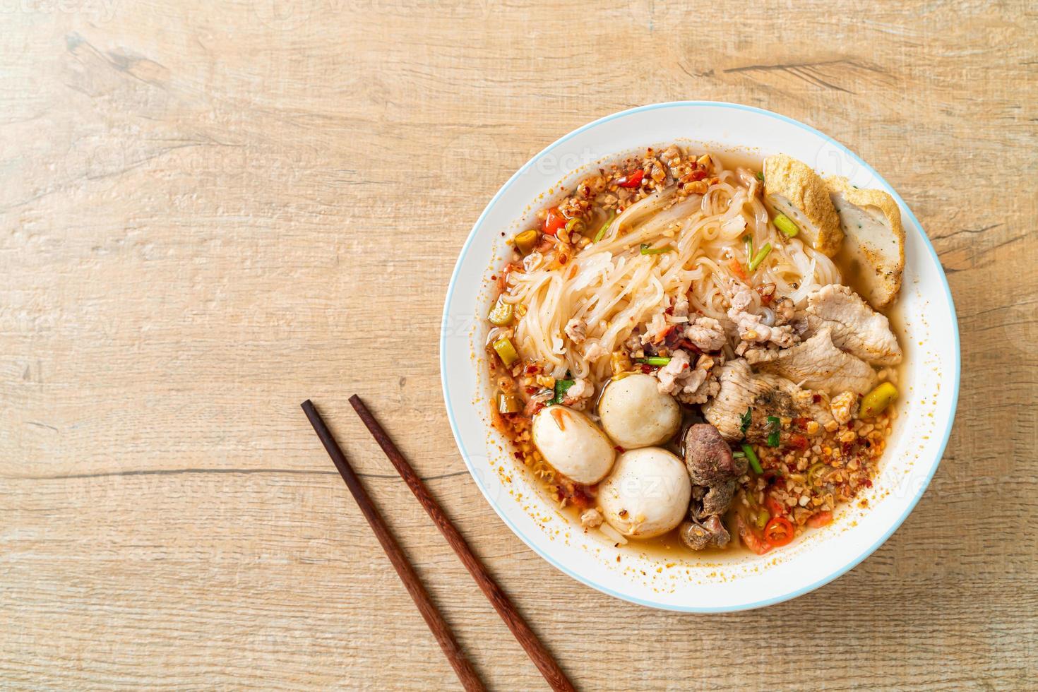 nouilles au porc et boulettes de viande dans une soupe épicée ou nouilles tom yum à l'asiatique photo