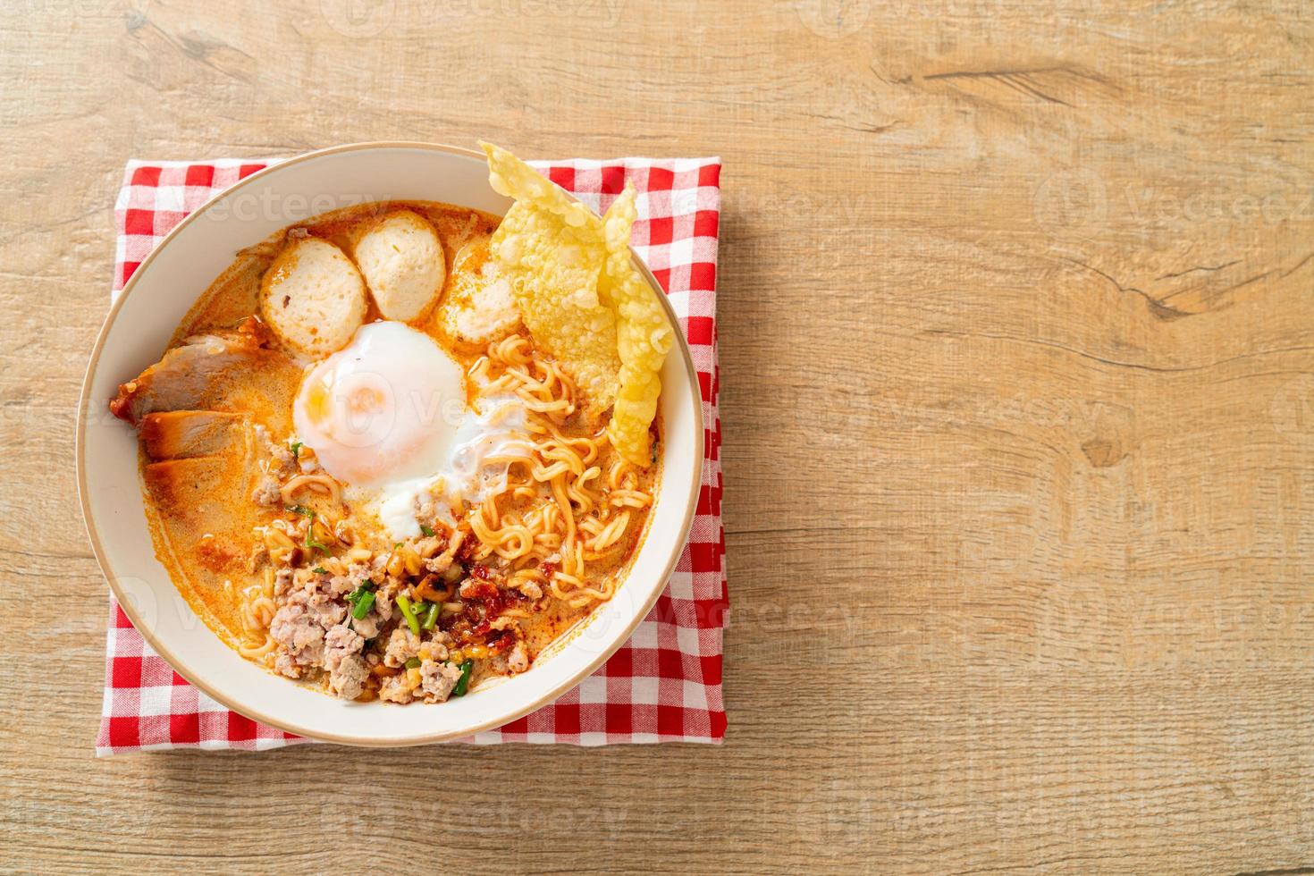 nouilles instantanées au porc et boulettes de viande dans une soupe épicée ou nouilles tom yum à l'asiatique photo