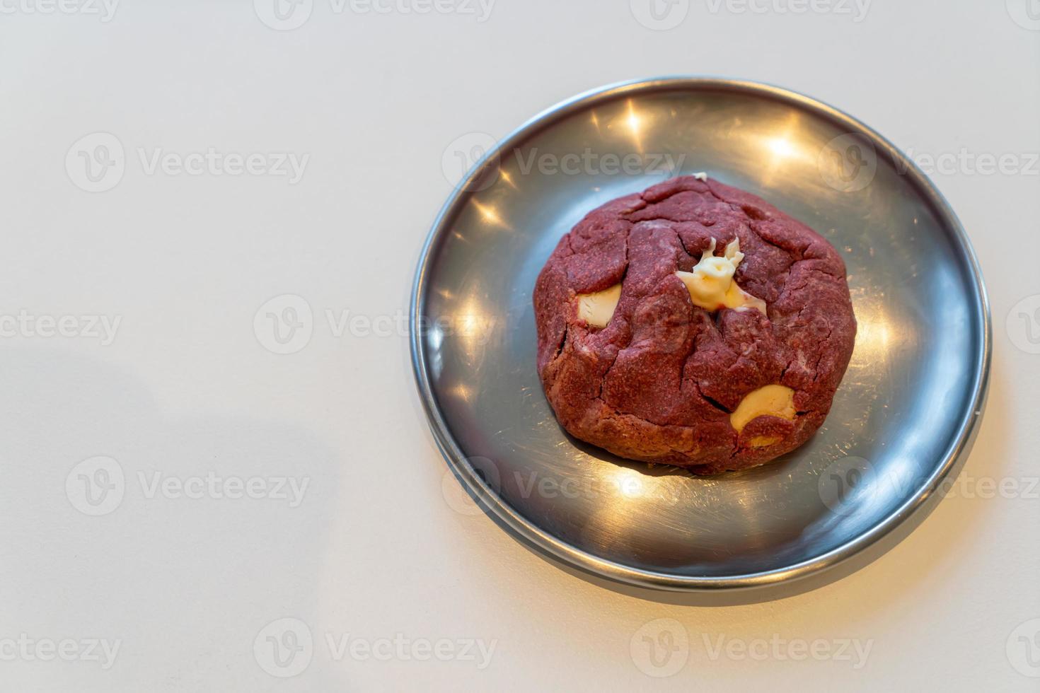 Biscuit de velours rouge avec noix de macadamia sur plaque photo