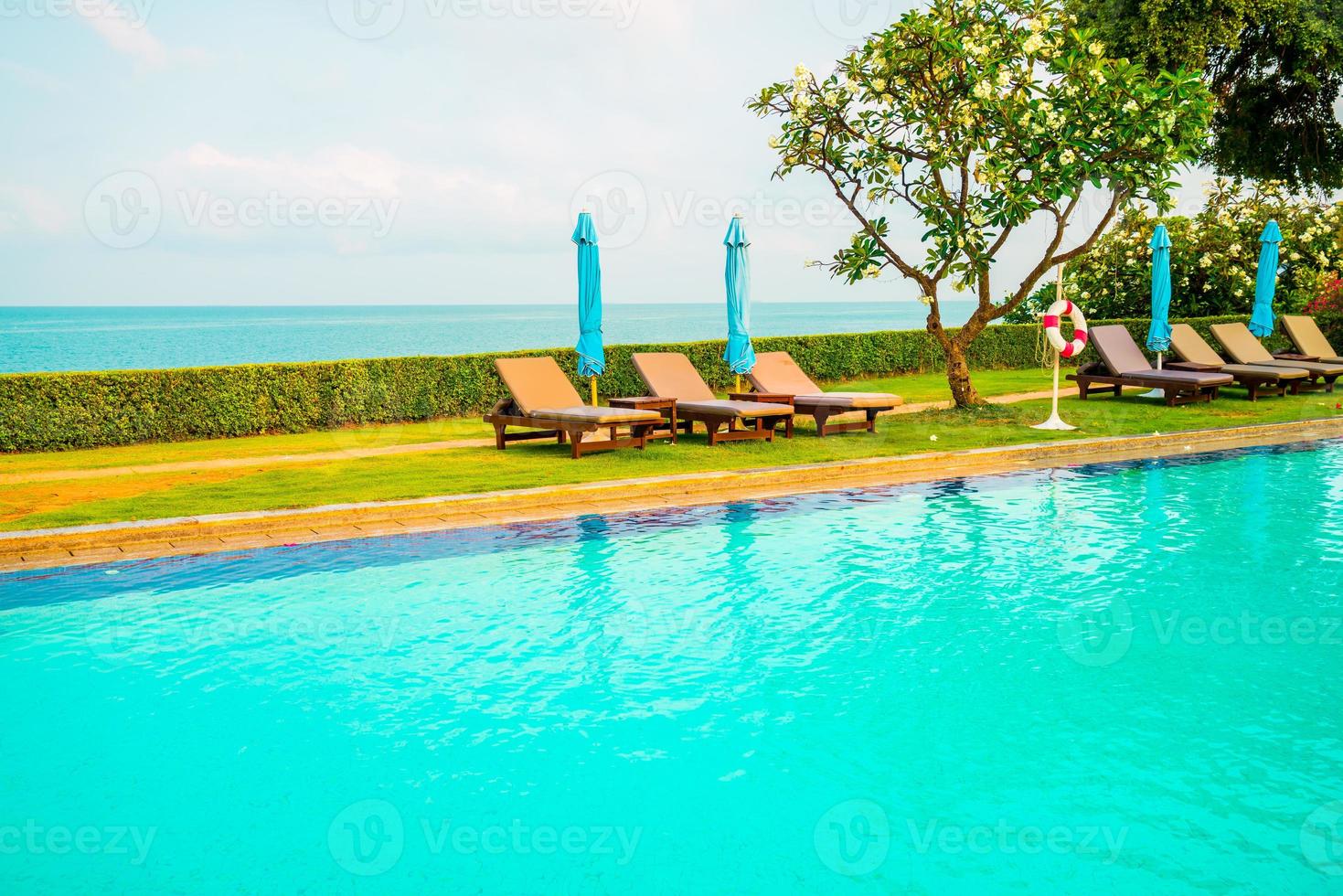 chaise piscine et parasol autour de la piscine avec fond de mer océan photo