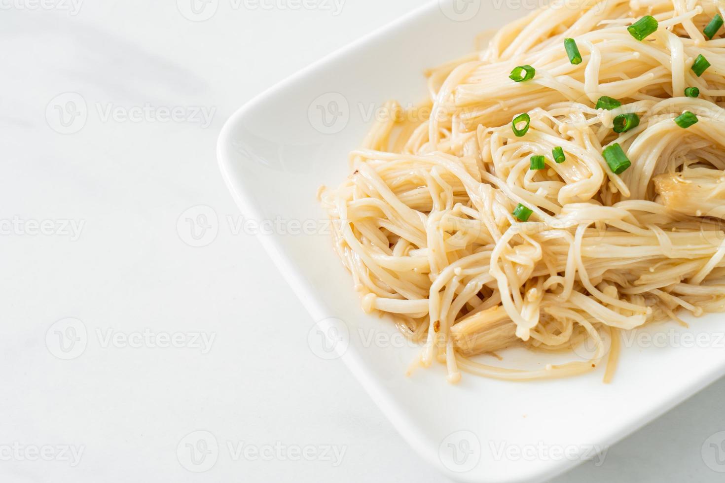 champignons d'aiguille d'or sautés avec du beurre sur une plaque blanche photo