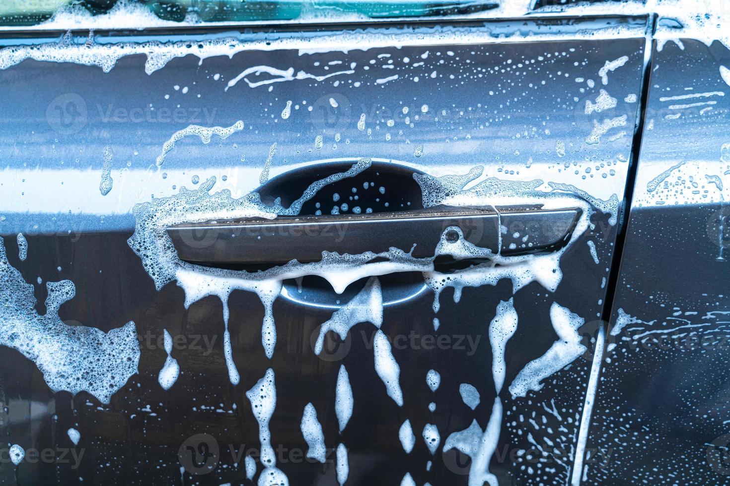 voiture grise en gros plan avec mousse de lavage photo