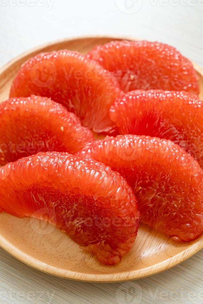 Pomelo rouge frais ou pamplemousse sur assiette photo