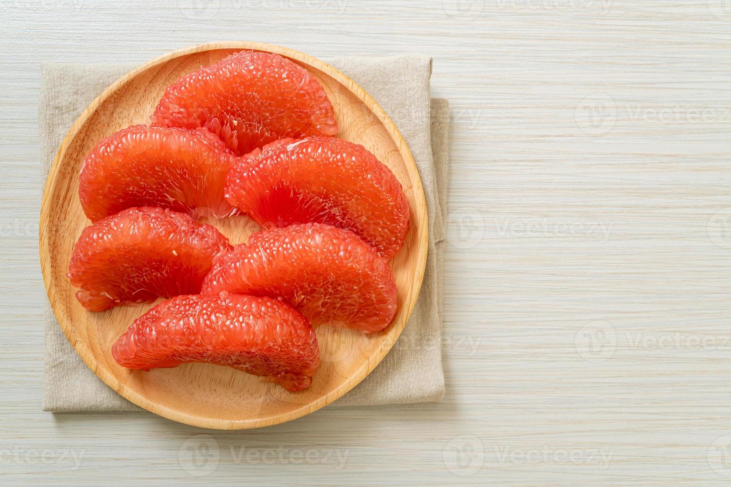 Pomelo rouge frais ou pamplemousse sur assiette photo