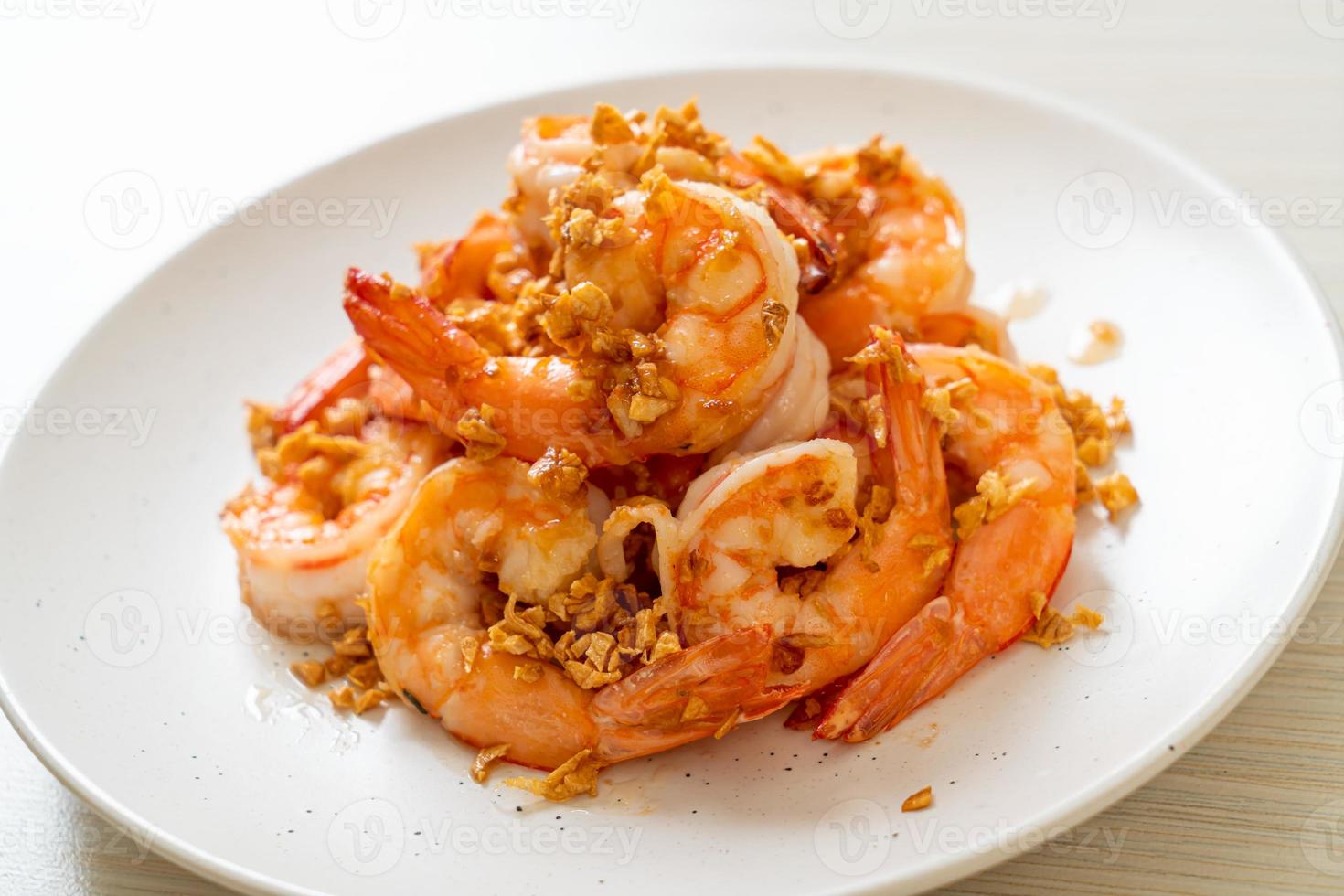 crevettes ou crevettes frites à l'ail sur une assiette blanche - style fruits de mer photo