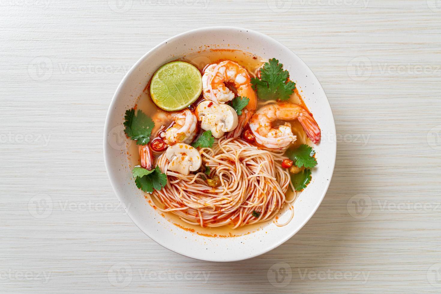 nouilles avec soupe épicée et crevettes dans un bol blanc - tom yum kung - style de cuisine asiatique photo