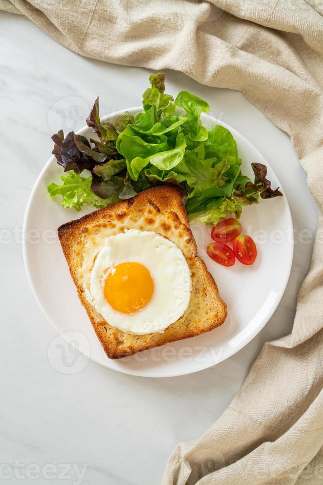 pain maison grillé avec du fromage et un œuf au plat sur le dessus avec une salade de légumes pour le petit-déjeuner photo