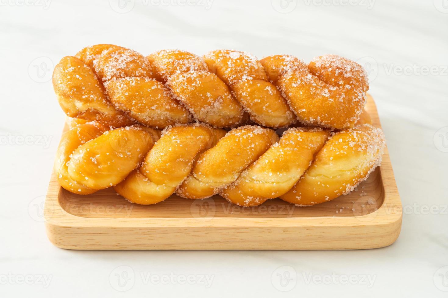 beignet de sucre en forme de spirale sur plaque de bois photo