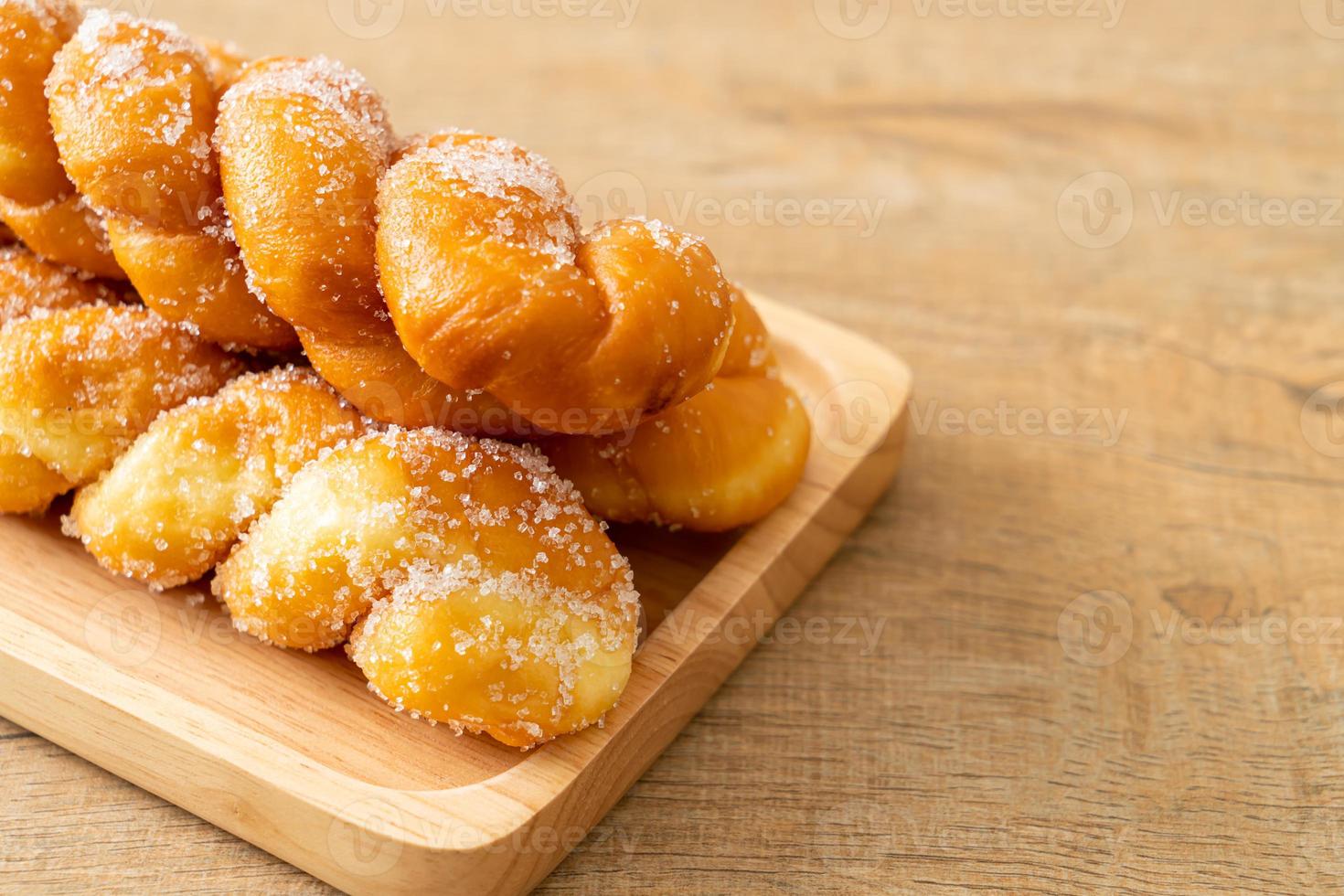 beignet de sucre en forme de spirale sur plaque de bois photo