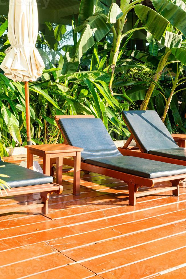 lits de piscine vides autour de la piscine avec parasols et soleil photo