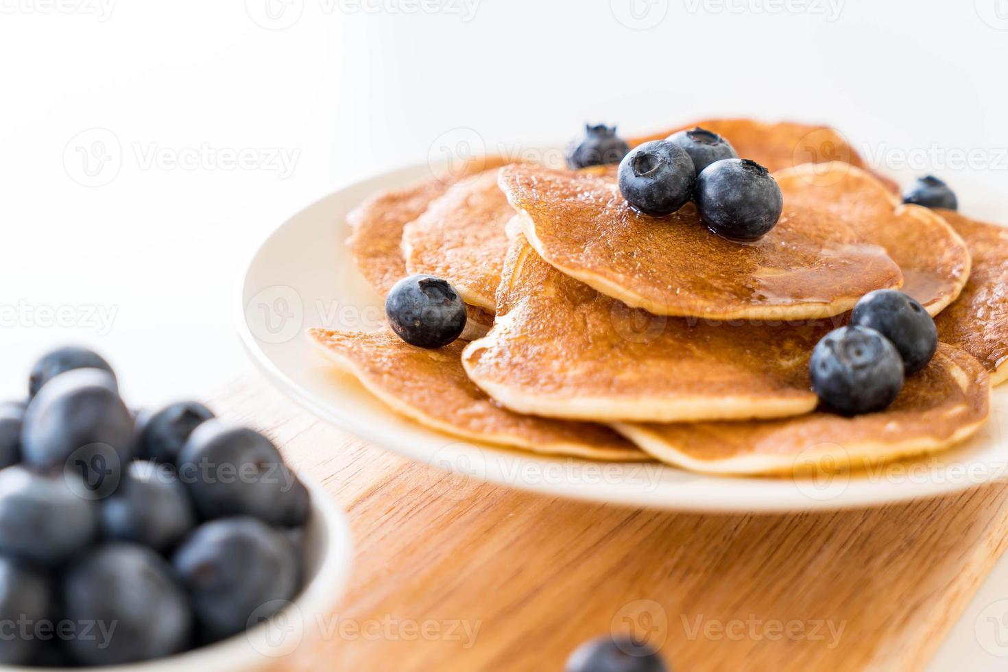 Pile de crêpes aux bleuets frais sur fond blanc photo