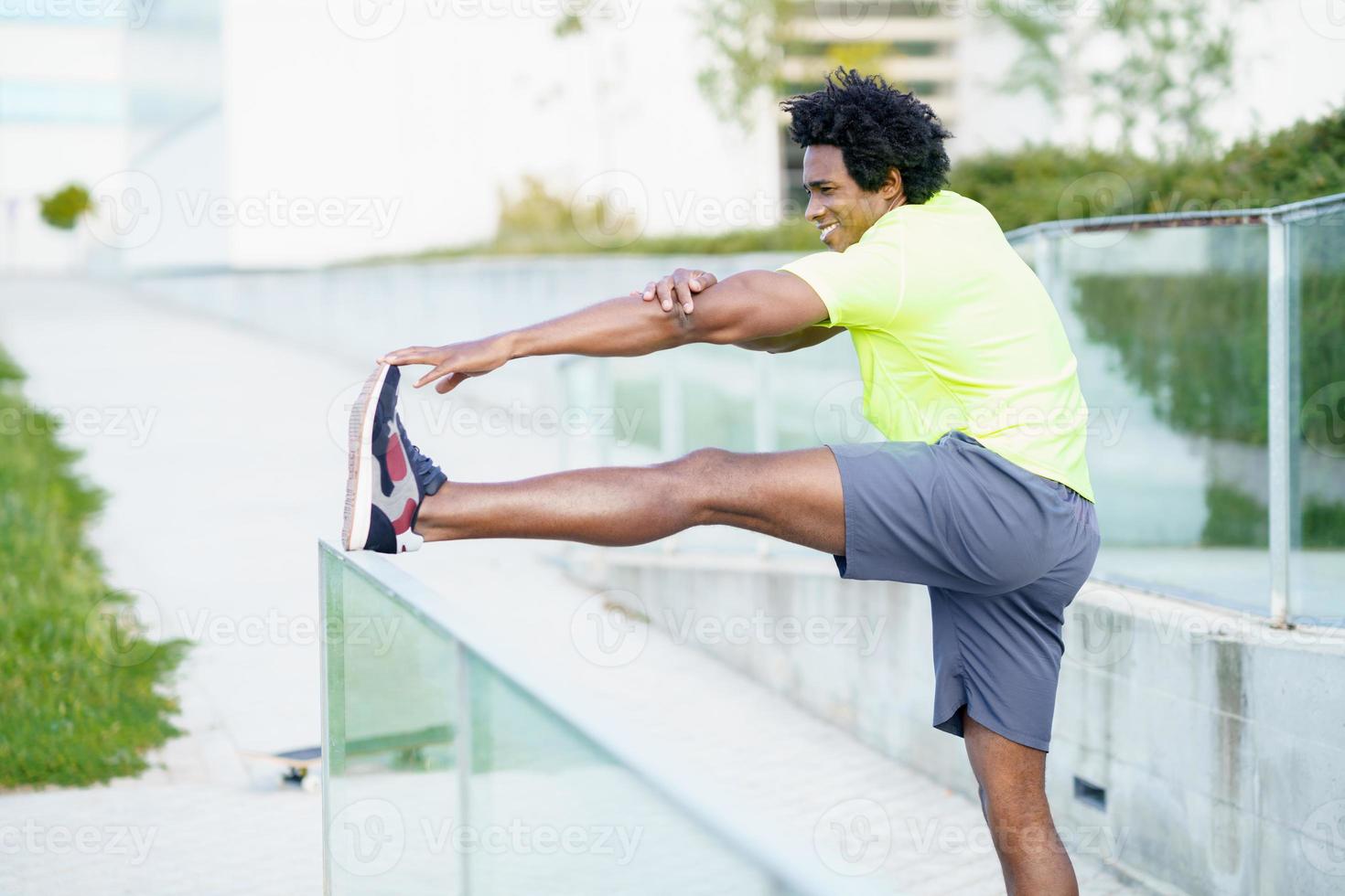 homme noir aux cheveux afro faisant des étirements après avoir couru à l'extérieur. photo