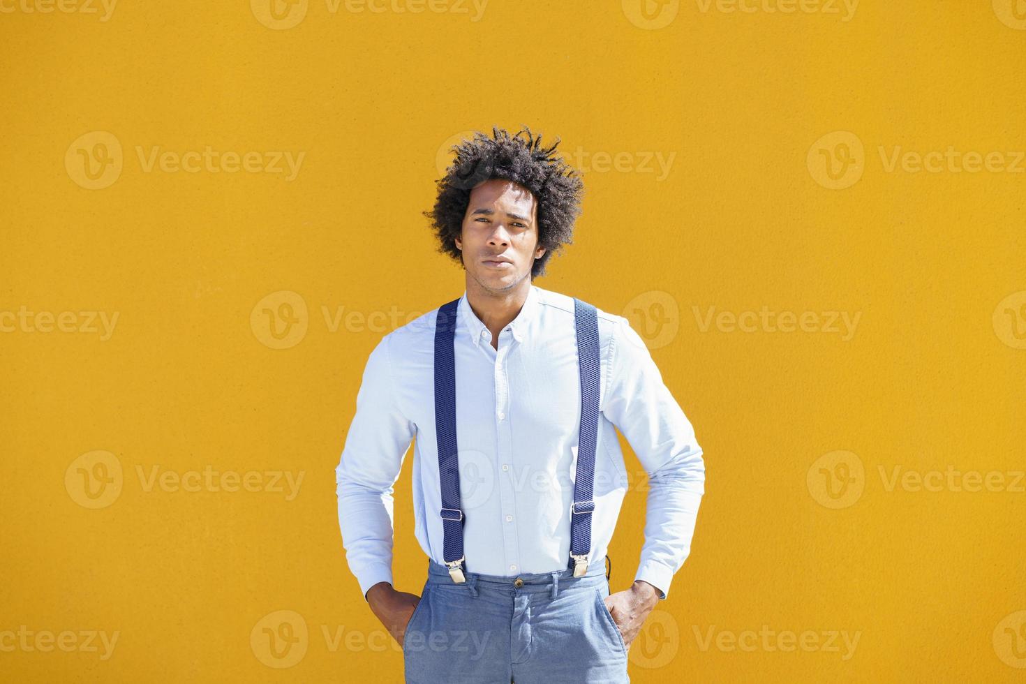 homme noir aux cheveux afro sur fond urbain jaune photo