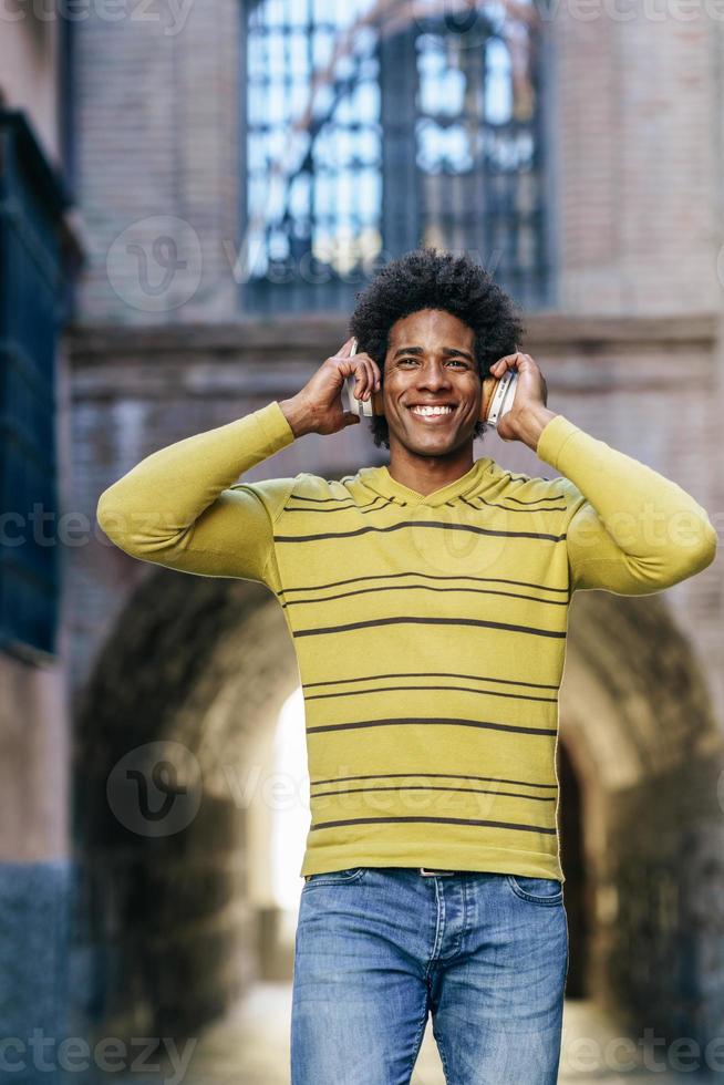 homme noir écoutant de la musique avec des écouteurs sans fil photo