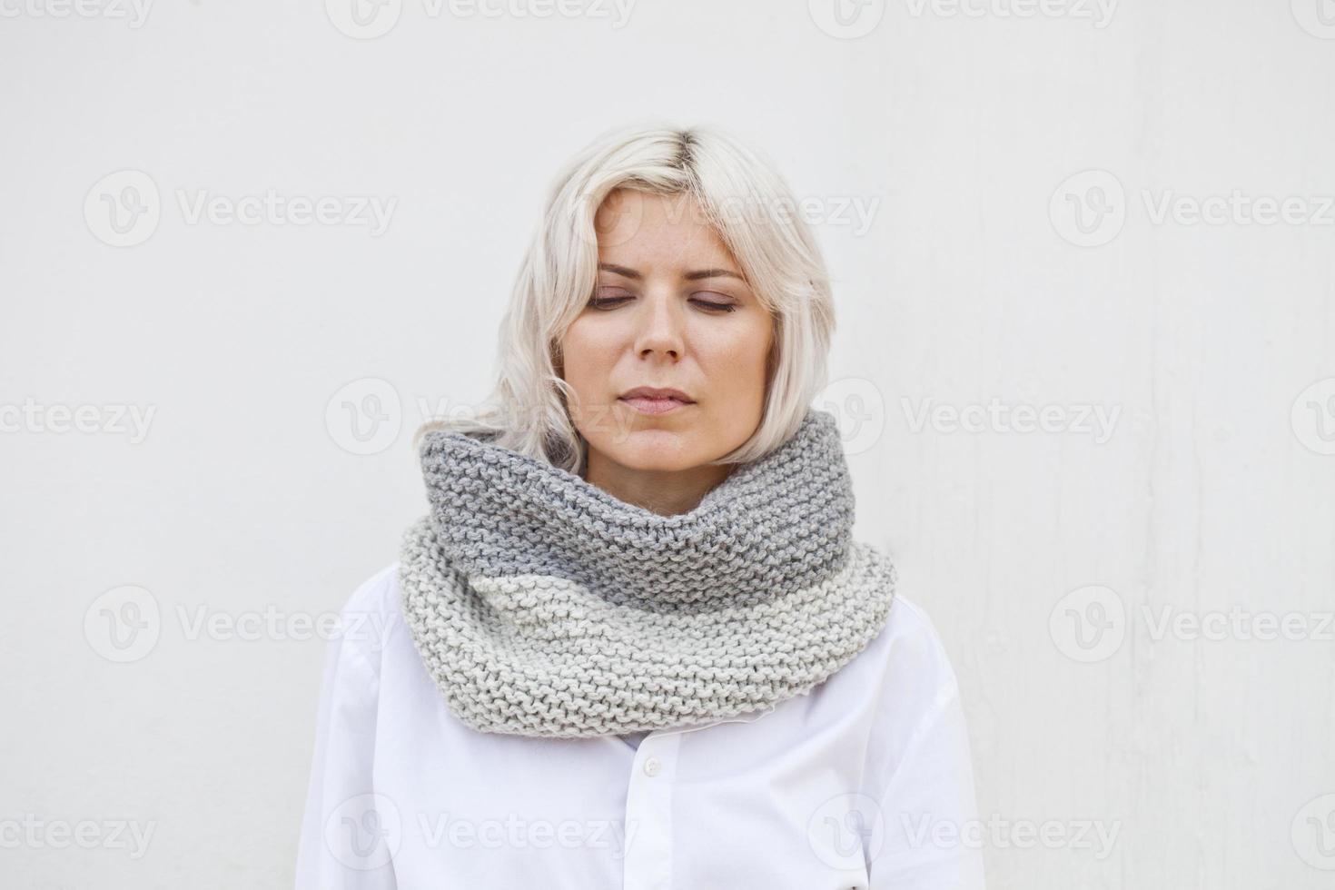 Jolie jeune femme en snood tricoté en laine grise chaude photo