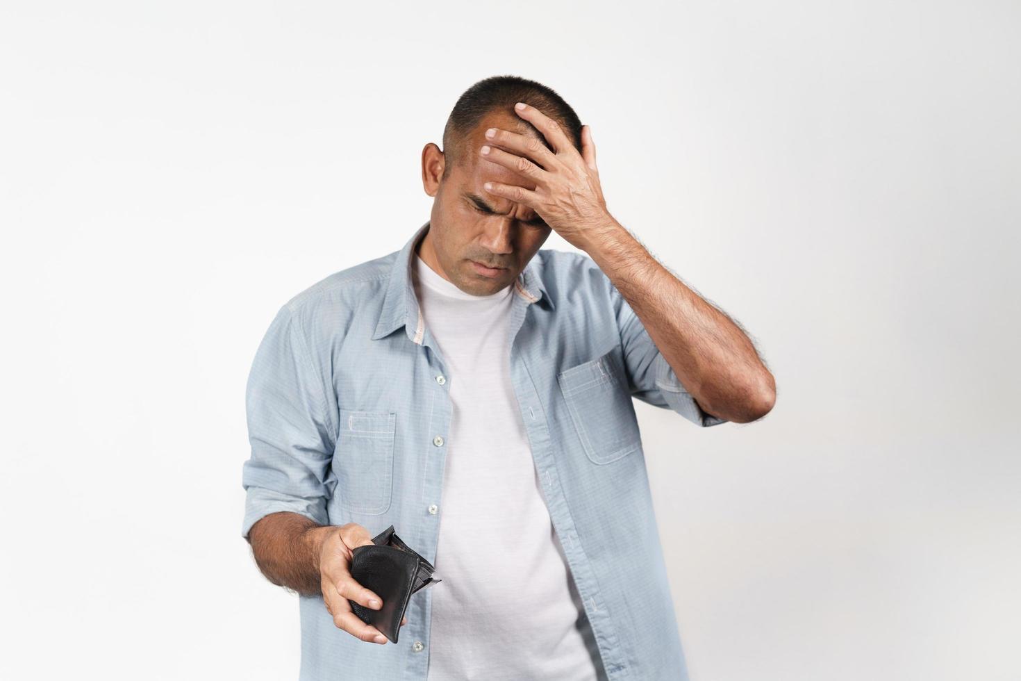 homme bouleversé tenant et regardant à l'intérieur de son portefeuille vide. pas d'argent. photo