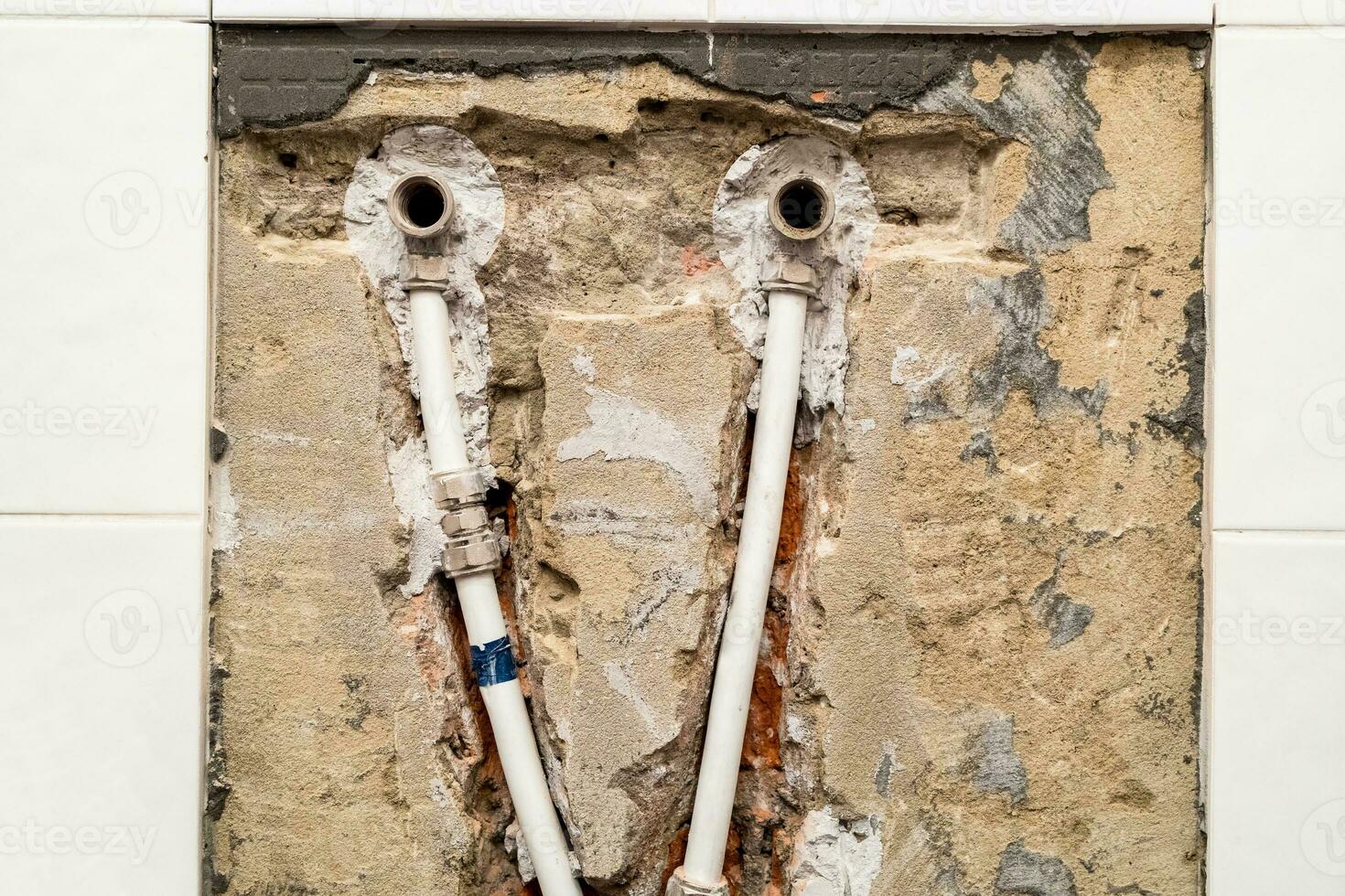 vieux plomberie avec métal-plastique tuyaux dans mur photo