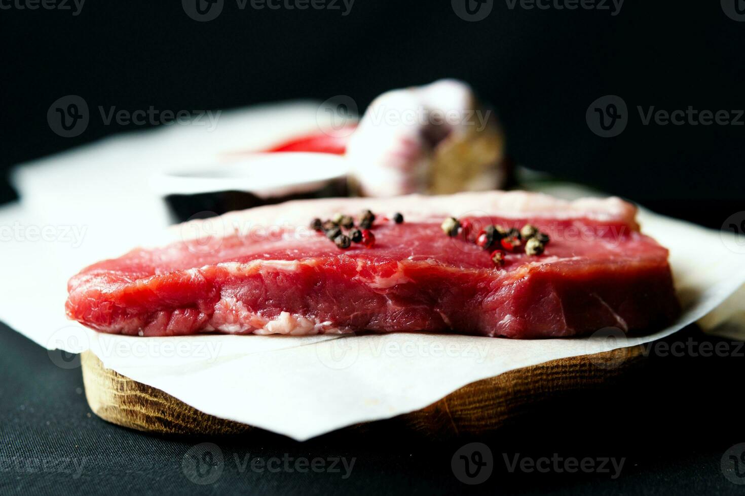 brut biologique du boeuf Viande avec Romarin, assaisonnements, sel et rouge poivre sur noir Contexte photo