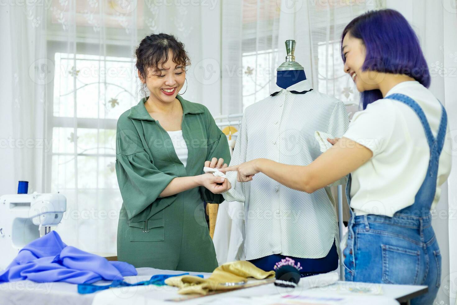 équipe de à la mode free-lance couturières choisir conception et style pour Nouveau Douane fabriqué robe tandis que travail avec mannequin atelier studio pour mode conception et Vêtements affaires industrie usage photo