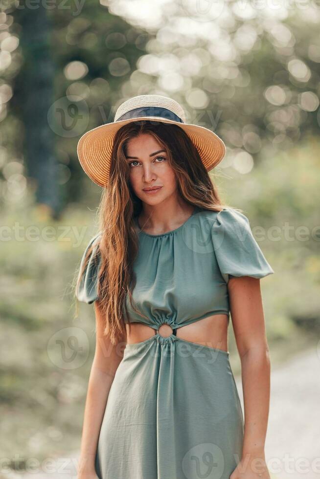 portrait de magnifique Jeune femme dans le forêt dans le des rayons de le Soleil Regardez à caméra photo