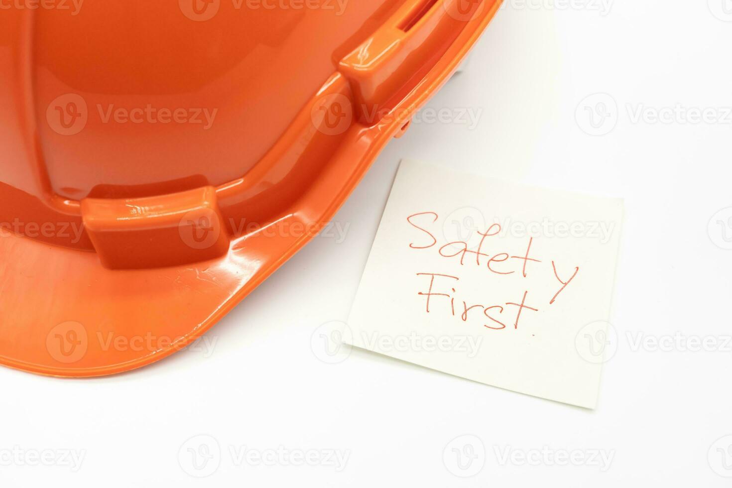 Orange sécurité chapeau avec message sécurité d'abord. difficile chapeau isolé sur blanc Contexte. photo