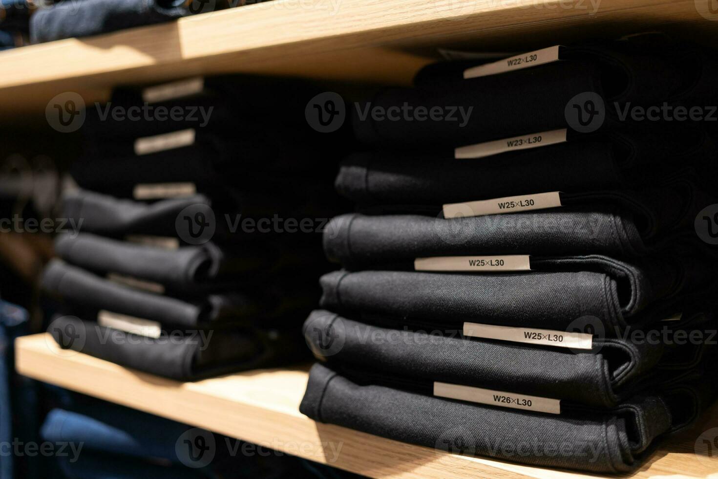 piles de plié jeans sur le magasin étagères dans le salle d'exposition ou magasin. vêtements stockage. mode vente au détail magasin à l'intérieur achats centre commercial. photo