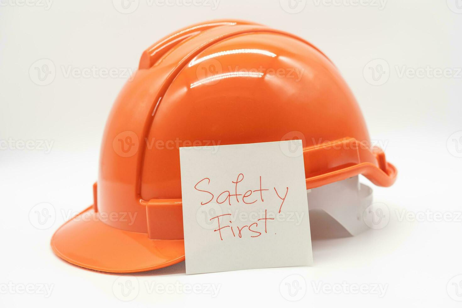 Orange sécurité chapeau avec message sécurité d'abord. difficile chapeau isolé sur blanc Contexte. photo