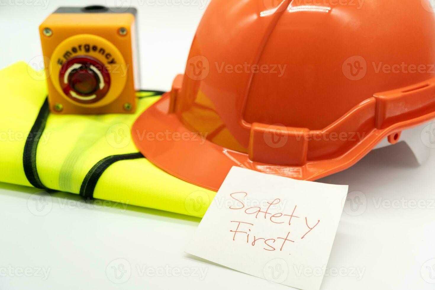 sécurité premier message sur papier. sécurité engrenage. réfléchissant gilet, sécurité chapeau ou casque et urgence Arrêtez bouton. sécurité premier concept. photo