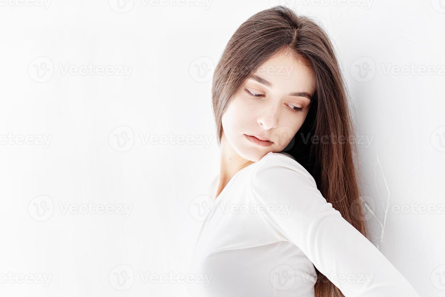 Jeune femme triste debout seule près du mur à l'écart photo