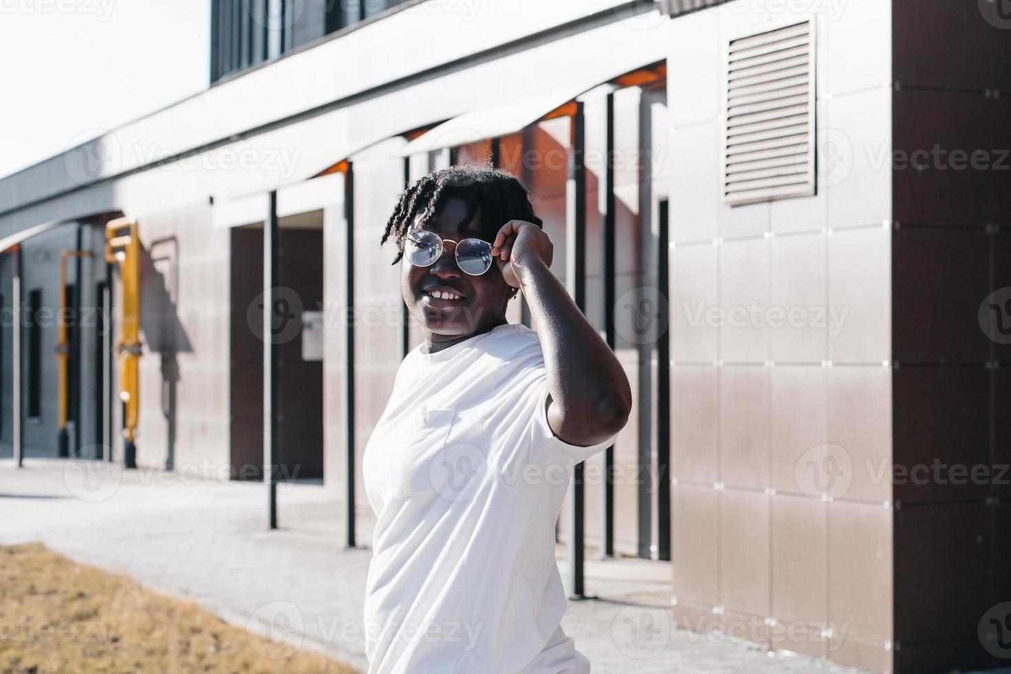 une femme afro-américaine heureuse marche dans la rue en été photo