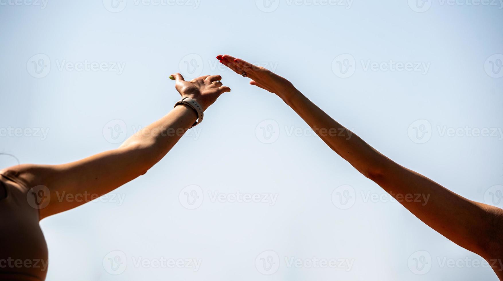 mains de personnes faisant du yoga sur la plage photo